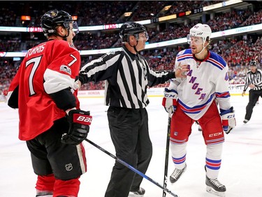 A linesman holds apart Kyle Turris and Brendan Smith in the third period.