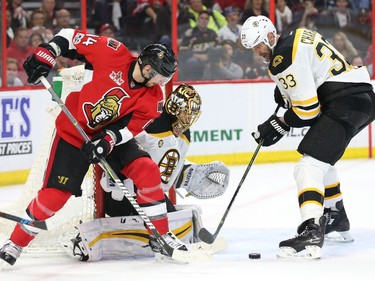 Alex Burrows of the Ottawa Senators battles for the puck against Tuukka Rask and Zdeno Chara.