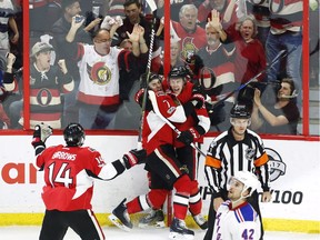 Ottawa Senators centre Ryan Dzingel (18) celebrates his goal with teammates centre Kyle Turris (7) and left wing Alex Burrows (14) as New York Rangers defenceman Brendan Smith (42) skates by during the second period in game one of a second-round NHL hockey Stanley Cup playoff series in Ottawa on Thursday, April 27, 2017.