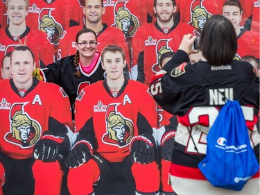 Alyssa Ferguson has her mom, Karen, take a photo of her with some cutouts of the team in the Red Zone.