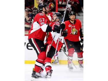 Ben Harpur hugs Jean-Gabriel Pageau with Marc Methot looking on as he celebrates his goal in the first period.