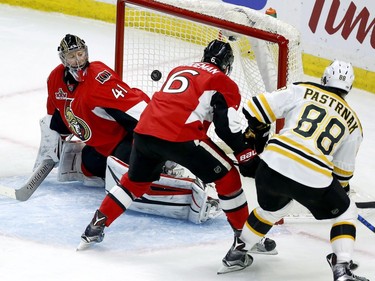 David Pastrnak chips the puck past Senators netminder Craig Anderson to score the Bruins' first goal of the game on Friday night.