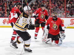 Brad Marchand of the Boston Bruins celebrates his game-winning goal against the Ottawa Senators as goalie Craig Anderson, Dion Phaneuf and Cody Ceci of the Ottawa Senators look on.