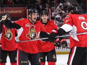 Teammate Bobby Ryan prepares a bear hug for Clarke MacArthur after his second-period power-play goal against the Bruins on Saturday.