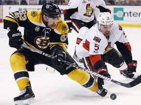 Boston Bruins' Brad Marchand (63) and Ottawa Senators' Cody Ceci (5) battle for the puck during the second period in game six of a first-round NHL hockey Stanley Cup playoff series, Sunday, April 23, 2017, in Boston.