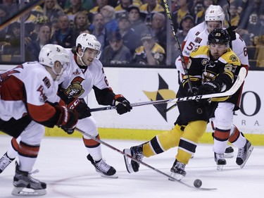 The Boston Bruins' Brad Marchand tries to thread through the Ottawa Senators.
