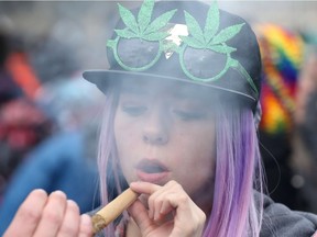 A woman smokes marijuana on Parliament Hill on 4/20 in Ottawa.