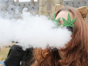 A woman smokes marijuana on Parliament Hill on 4/20 in Ottawa, Ontario, April 20, 2017.