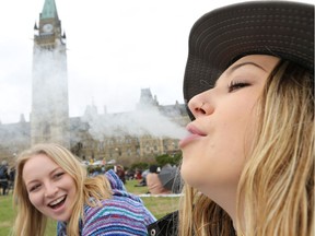 Two women smoke marijuana on Parliament Hill during 4/20 in Ottawa.