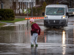 Claire Tetreault tests water levels in front of her house on rue Jacques Cartier.