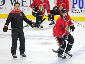 Coach Guy Boucher looks on as Erik Karlsson skates a drill as the Ottawa Senators practice at the Canadian Tire Centre in preparation for Round 2 against the New York Rangers in the NHL playoffs.