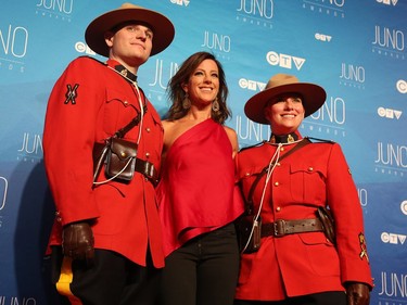 Constables Zachary MacMillan (L) and Marie-Michele Ouimet flank Sarah McLachlan as musical talent take to the red carpet at the Juno Awards held on Sunday at the Canadian Tire Centre.