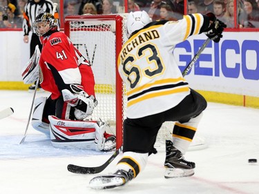 The Senators' Craig Anderson looks over at Brad Marchand in the second period as the puck slips by the net.