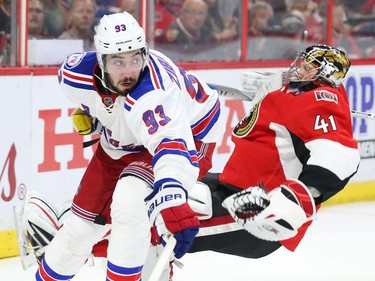 Craig Anderson of the Ottawa Senators is tripped up by Mika Zibanejad of the New York Rangers.