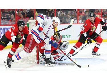 Craig Anderson of the Ottawa Senators makes the save on Michael Grabner of the New York Rangers as Dion Phaneuf,
 left, and Cody Ceci look on.