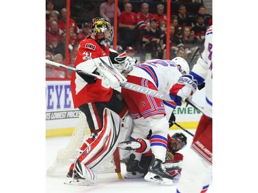 Craig Anderson of the Ottawa Senators tries to get his leg out of his net as Viktor Stalberg battles against Nick Holden of the New York Rangers.