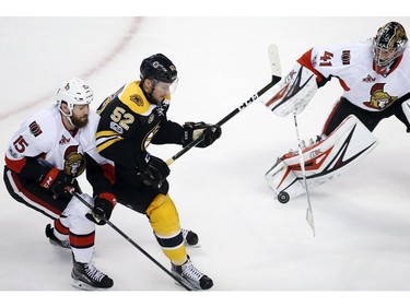 Boston Bruins' Sean Kuraly (52) and Ottawa Senators' Zack Smith battle for the puck in front of Ottawa goalie Craig Anderson (41) during the third period in game six of a first-round NHL hockey Stanley Cup playoff series, Sunday, April 23, 2017, in Boston. The Senators won 3-2.
