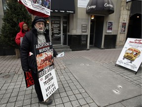 A protester stands on Bank St. just outside The Morgentaler Clinic on Monday December 07, 2015.