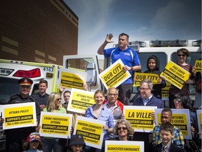 Councillor Tim Tierney addressed the crowd while standing on a fire truck with many supporters at a community safety march on Jasmine Crescent Sunday April 9, 2017.   Ashley Fraser/Postmedia