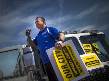 Cyrville Councillor Tim Tierney addressed the crowd while standing on a fire truck at a community safety march on Jasmine Crescent Sunday April 9, 2017.   Ashley Fraser/Postmedia