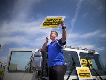 Cyrville Councillor Tim Tierney addressed the crowd while standing on a fire truck at a community safety march on Jasmine Crescent Sunday April 9, 2017.   Ashley Fraser/Postmedia