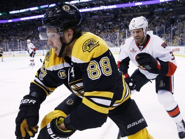 Boston Bruins' David Pastrnak (88), of the Czech Republic, and Ottawa Senators' Marc Methot (3) battle along the boards during the second period in game six of a first-round NHL hockey Stanley Cup playoff series, Sunday, April 23, 2017, in Boston.