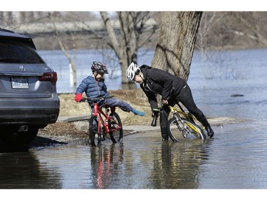 Dominique Lalonde helps her son Maxime Letourneau empty his waterlogged boots before continuing their ride.