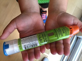 This August 24, 2016 photo taken in Hudson, Wisconsin shows a youngster holding Epipens, that he uses to counteract allergic reactions. A five-fold price hike for EpiPen, which allergy sufferers use to counteract life-threatening reactions, has made Mylan the newest drugmaker to come under attack in the United States for profiteering. Mylan Pharmaceuticals, which holds a near-monopoly position on the epinephrine injectors used by millions against severe allergic attacks, was assailed by two powerful US senators for pumping up the price over six years from $100 to more than $500. That has rendered EpiPens unaffordable to many sufferers -- who must replace them each year -- and is costing the government huge sums to stock schools with them and fund insurance programs which pay for them, the lawmakers said Monday.  / AFP PHOTO / Lucas TRIEBLUCAS TRIEB/AFP/Getty Images