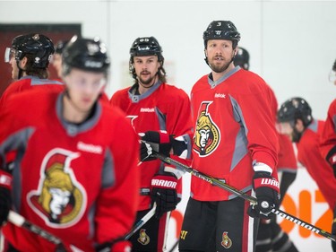 Erik Karlsson, middle, and Marc Methot wait for their turn at a drill during Senators practice on Friday.