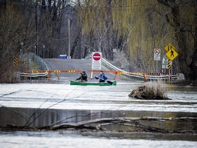 Flooding of the Ottawa River has caused the city to close Trim Road going into Petrie Island Saturday April 22, 2017. Paddlers L-R Oliver Bibeau and Chris Tyler make their way along where Trim Road would normally be.