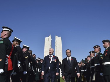 French President Francois Hollande, center right, and Governor General of Canada David Johnston walk past an honor guard as part of the commemorations of the 100th anniversary of the Battle of Vimy Ridge at the WWI Canadian National Vimy Memorial in Vimy, France, Sunday, April 9, 2017. The commemorative ceremony at the memorial honors Canadian soldiers who were killed or wounded during the Battle of Vimy Ridge in April 1917.