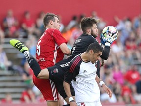 Fury FC keeper Callum Irving clutches a high ball as he gets squeezed between teammate Onua Obasi, front, and the Kickers' Conor Shanosky during Saturday's match at Richmond, Va. Brian Zimmerman photo