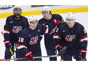 Colin White, front left, and Charlie McAvoy, back right, have played together on U.S. national teams and both were university hockey stars in Boston.