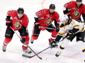 Senators forward Chris Kelly, middle, joins Dion Phaneuf and Clarke MacArthur in surrounding the Bruins' David Backes.