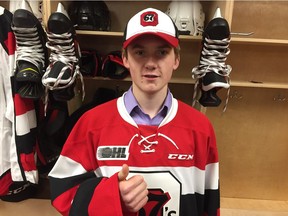 Graeme Clarke dons a 67's jersey after being selected sixth overall in the first round by the team on Saturday.  Tim Baines/Postmedia.