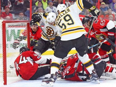 Jean-Gabriel Pageau (L) of the Ottawa Senators saves a goal against the Boston Bruins during first period of overtime.