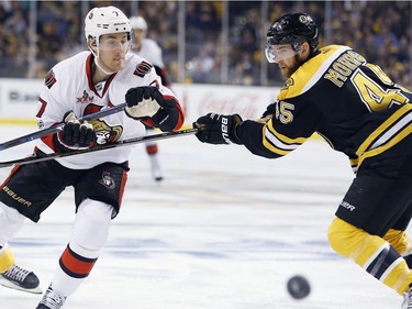 Boston Bruins' Joe Morrow (45) and Ottawa Senators' Kyle Turris (7) battle for the puck during the first period in Game 6 of a first-round NHL hockey Stanley Cup playoff series, Sunday, April 23, 2017, in Boston.