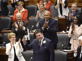 Ontario Finance Minister Charles Sousa delivers the 2017 Ontario budget next to Premier Kathleen Wynne at Queen's Park in Toronto on Thursday.