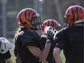 Laurie-Ange Clément takes a water break during spring training at Hormisdas-Gamelin High School in Buckingham, QC, on April 27, 2017. The football team is now inviting girls to play full contact football with the boys.  (David Kawai)
