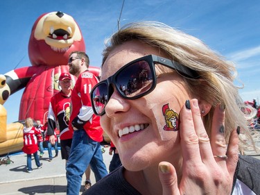 Lezlie Cooper, who came to Ottawa for games 1 and 2 from Goose Bay, Labrador, sticks a Sens sticker on her cheek while enjoying the action in the Red Zone.