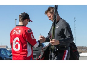 Marc Methot, with his injured left pinky finger bandaged up, signs an autograph for Dylan Sullivan as the Ottawa Senators practice at the Bell Sensplex in advance of their next NHL playoff game against the Boston Bruins on Saturday. The Bruins are up 1-0 in a best of seven series.