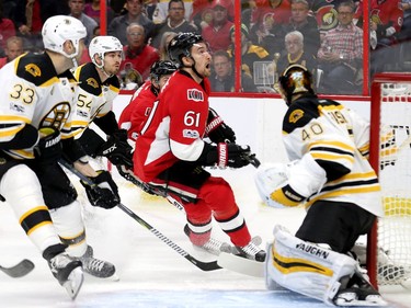 Mark Stone looks for the puck as he moves in on the Boston goalie, Tuukka Rask, with Zden Chara, left, and Adam McQuaid close behind in the first period.