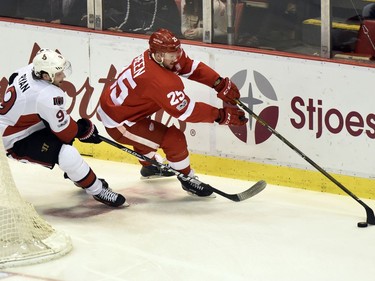 Detroit Red Wings defenseman Mike Green (25) keeps the puck away from Ottawa Senators right wing Bobby Ryan (9) during the first period of an NHL hockey game, Monday, April 3, 2017, in Detroit.