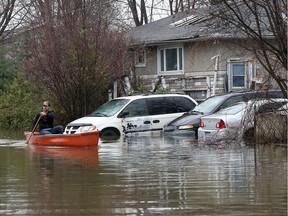 Réjean Belcourt paddles down Saint-Francois-Xavier Street Gatineau in a canoe Friday April 21, 2017. More rain Friday caused more flooding in Gatineau. Rejoin decided to make the best of it as he paddled around the block he lives on Friday.