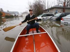 Réjean Belcourt paddles down Saint-François-Xavier Street  Gatineau in a canoe Friday April 21, 2017. More rain Friday caused more flooding in Gatineau. Rejoin decided to make the best of it as he paddled around the block he lives on Friday.  Tony Caldwell