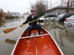 Réjean Belcourt paddles down Saint-François-Xavier Street Gatineau in a canoe Friday April 21, 2017. More rain Friday caused more flooding in Gatineau. Belcourt decided to make the best of it as he paddled around the block he lives on Friday.