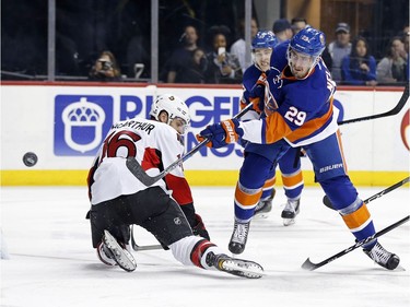 New York Islanders center Brock Nelson (29) takes a shot on net past Ottawa Senators left wing Clarke MacArthur (16) in the second period of an NHL hockey game, Sunday, April 9, 2017, in New York.