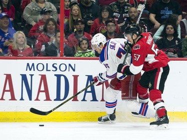 New York Rangers #16 Brady Skjei keeps the puck from Ottawa Senators #57 Tommy Wingels during the first period of play at Canadian Tire Centre Saturday April 8, 2017.