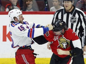 Senators defenceman Mark Borowiecki, right, fights with the Rangers' Tanner Glass during the first period of Saturday's game.