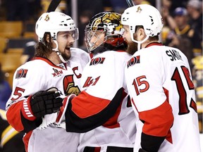 Ottawa Senators captain Erik Karlsson celebrates with goalie Craig Anderson and Zack Smith after a 1-0 win over Boston in Game 4 on Wednesday night.
